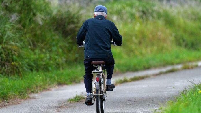 Arthrose Arthrose: älterer Mann fährt mit dem Fahrrad über einen Landweg